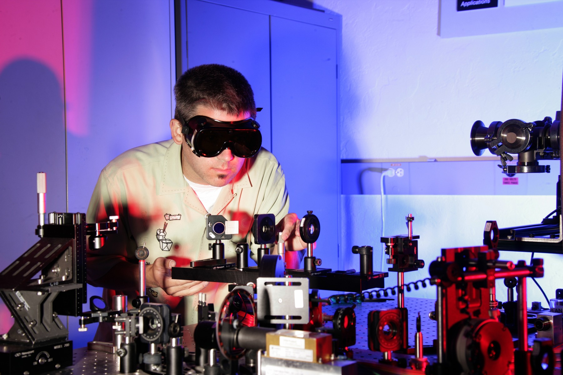 A laser laboratory with red beam paths across an optical table