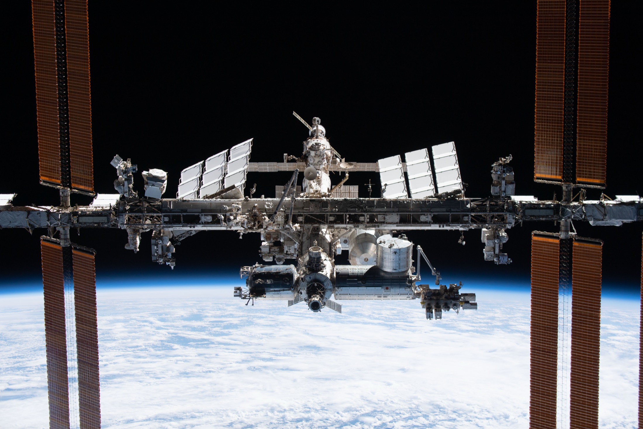 The International Space Station, its white radiator panels against black space